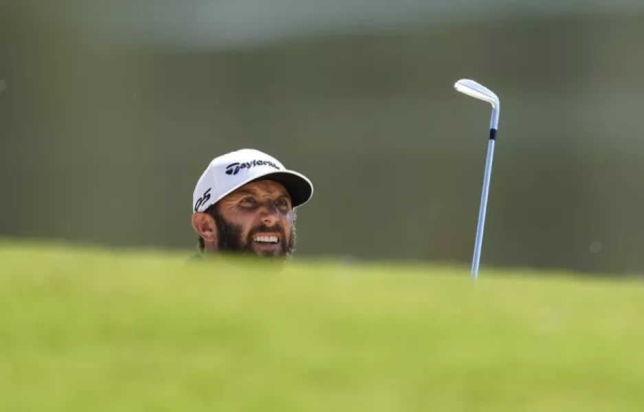 Dustin Johnson peeks out from the bunker on the eighth hole during the final round of the Tour Championship (John Bazemore/AP)