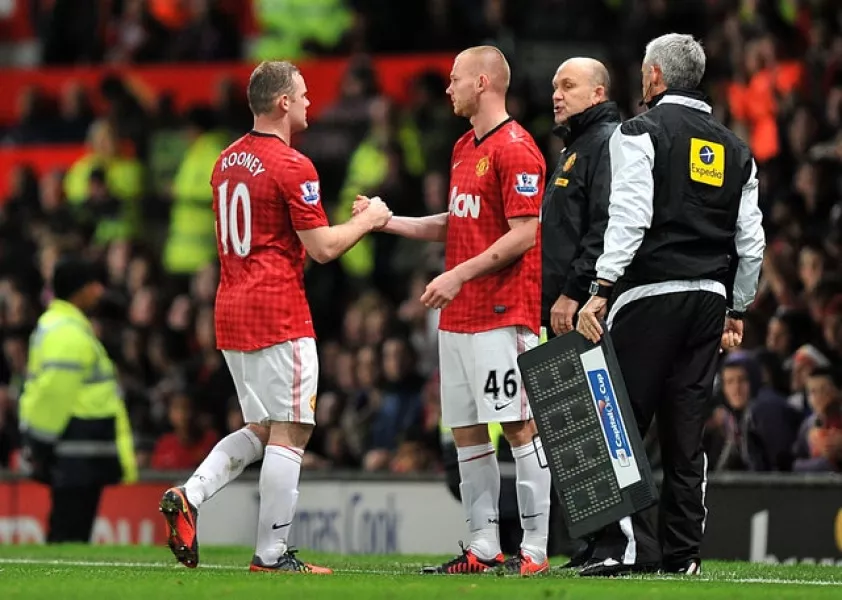 Ryan Tunnicliffe shakes hands with Wayne Rooney before coming on for his Manchester United debut in 2011 (Martin Rickett/PA)
