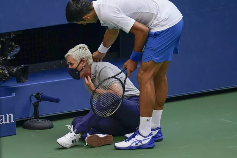 Djokovic checks on the condition of the line judge as she holds her throat (Seth Wenig/AP)