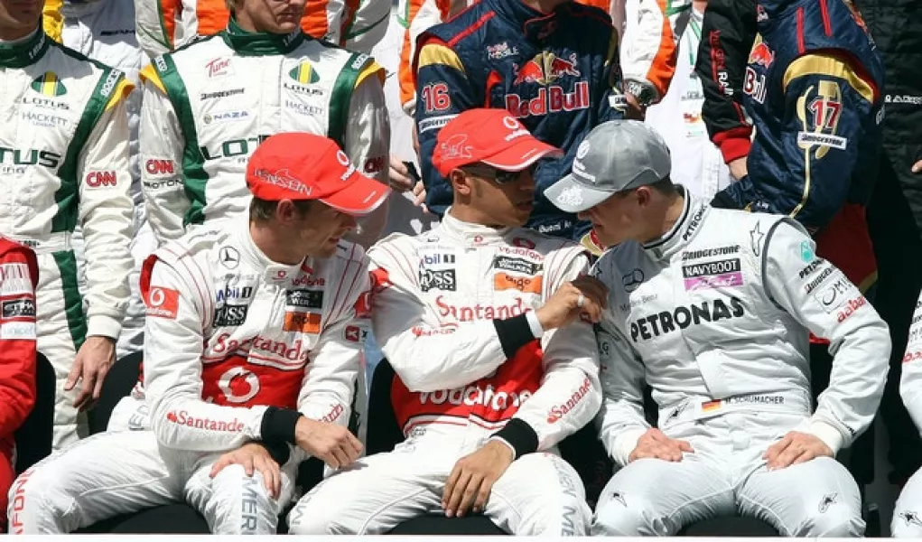 Lewis Hamilton and Jenson Button chat with Michael Schumacher (David Davies/PA)