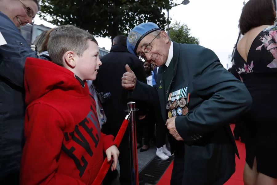 At a special screening of The Siege of Jadotville in 2016, veteran of the siege Jimie Taheny from Roscommon shows his medals to Sean Paul (7) from Cheery Orchard. Picture Andres Poveda / Netflix 