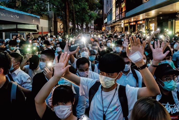 Protesters light up their mobile phones as they take part in a rally in Hong Kong last month. Picture: Getty
