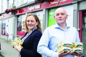 A man and a woman stand outside Supervalu holding 