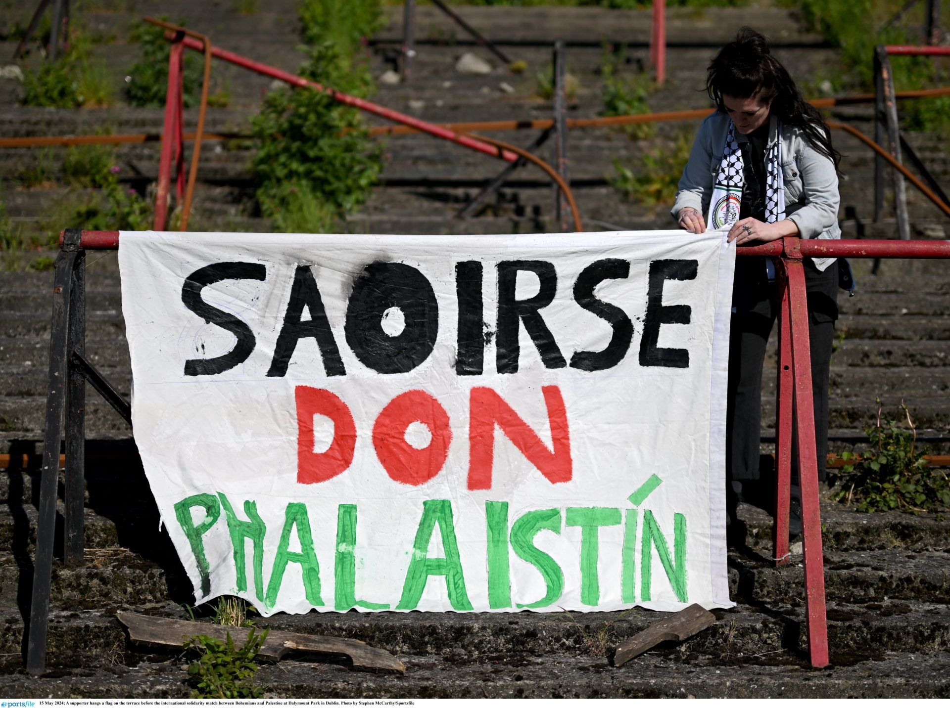 15 May 2024; A supporter hangs a flag on the terrace before the international solidarity match between Bohemians and Palestine at Dalymount Park in Dublin. Photo by Stephen McCarthy/Sportsfile