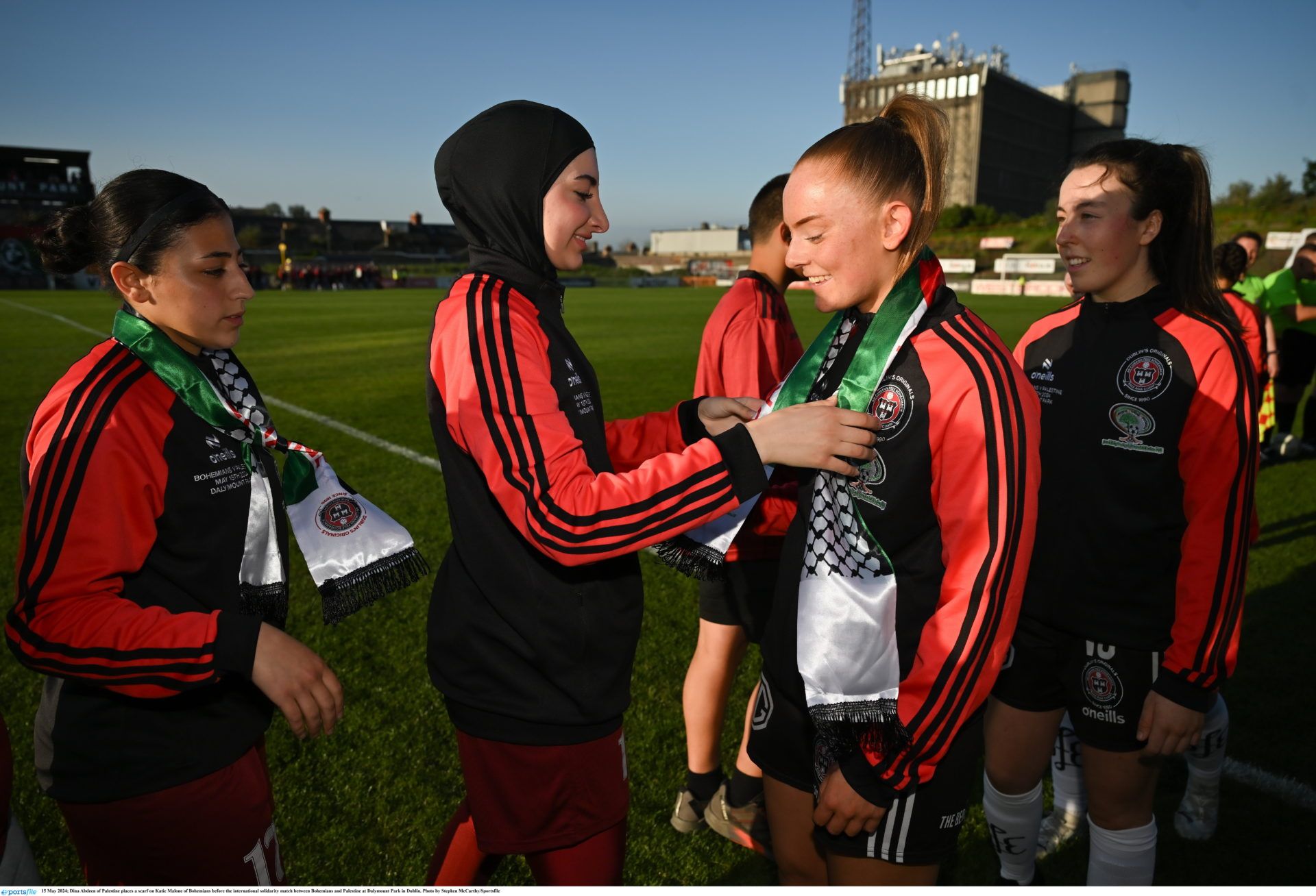 15 May 2024; Dina Abdeen of Palestine places a scarf on Katie Malone of Bohemians before the international solidarity match between Bohemians and Palestine at Dalymount Park in Dublin. Photo by Stephen McCarthy/Sportsfile