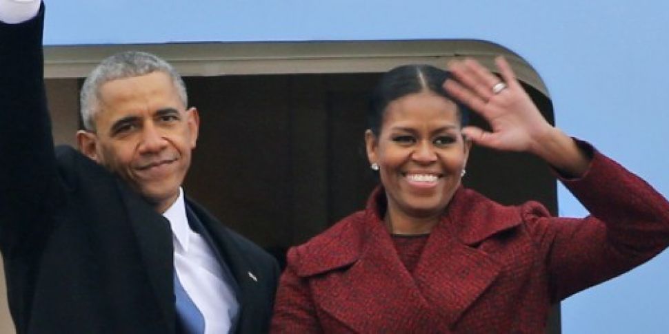 Barack and Michelle Obama sign...