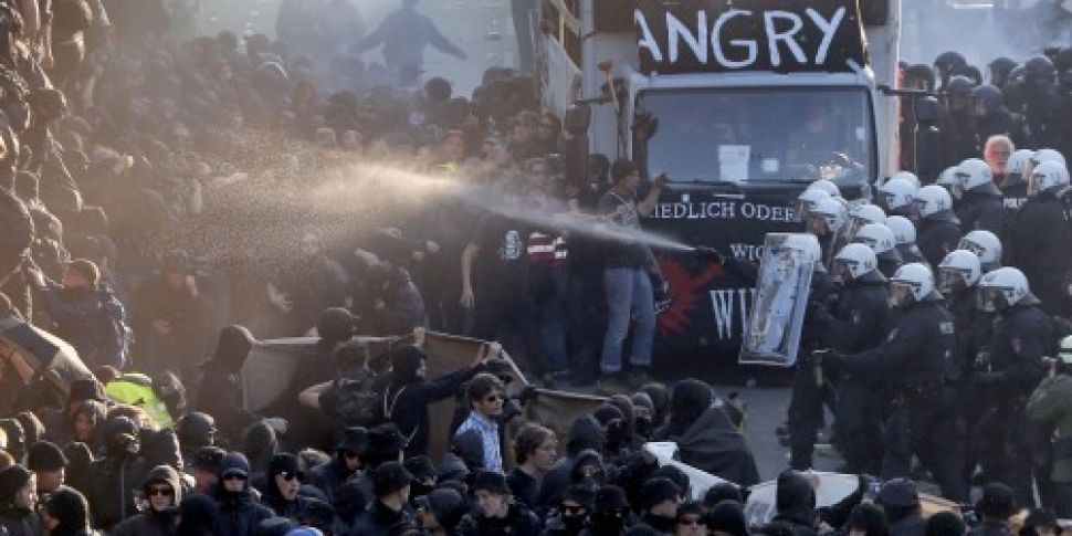 Riot police fire water cannon...