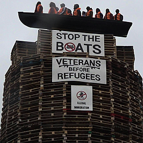 Loyalist bonfire containing an effigy of migrants condemned Image