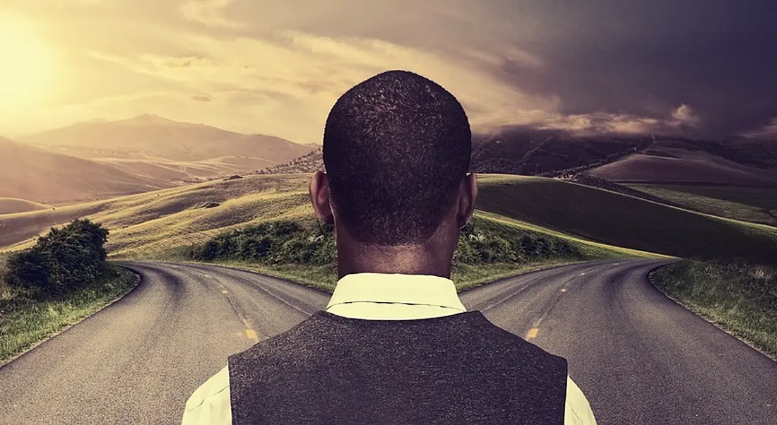 Man stands at a fork in the road