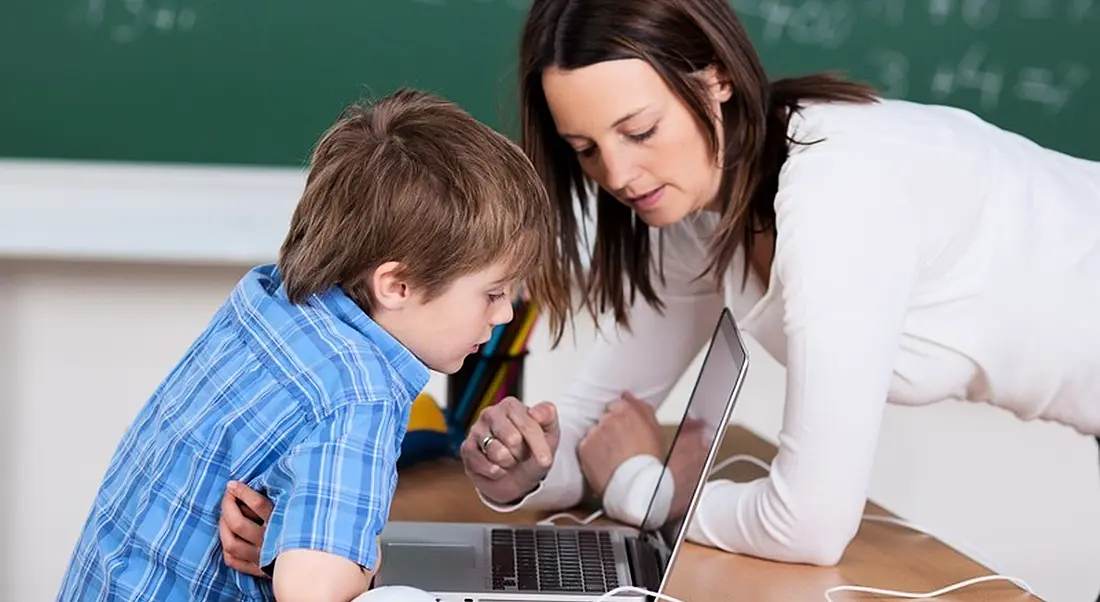 Teachers showing student how to work on computer