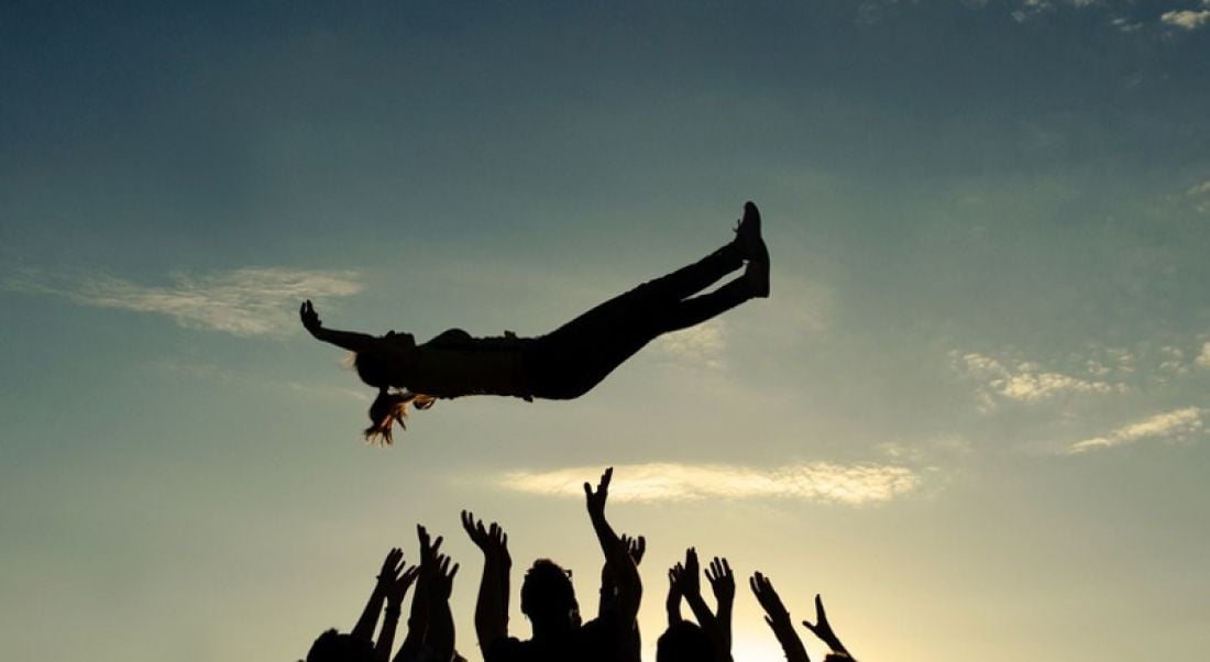 Tech industry: group of people throwing someone up in the air in celebration