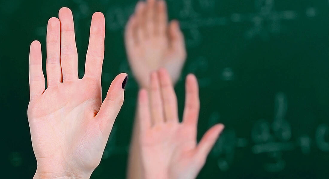 Christ King: raised hands in a classroom