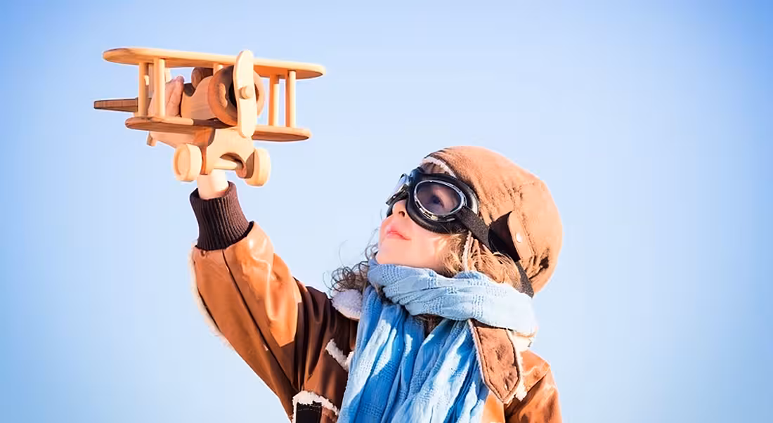 STEM: young child playing with wooden bi-plane