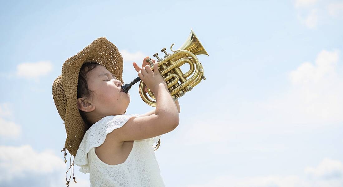 Girl playing trumpet triumphantly