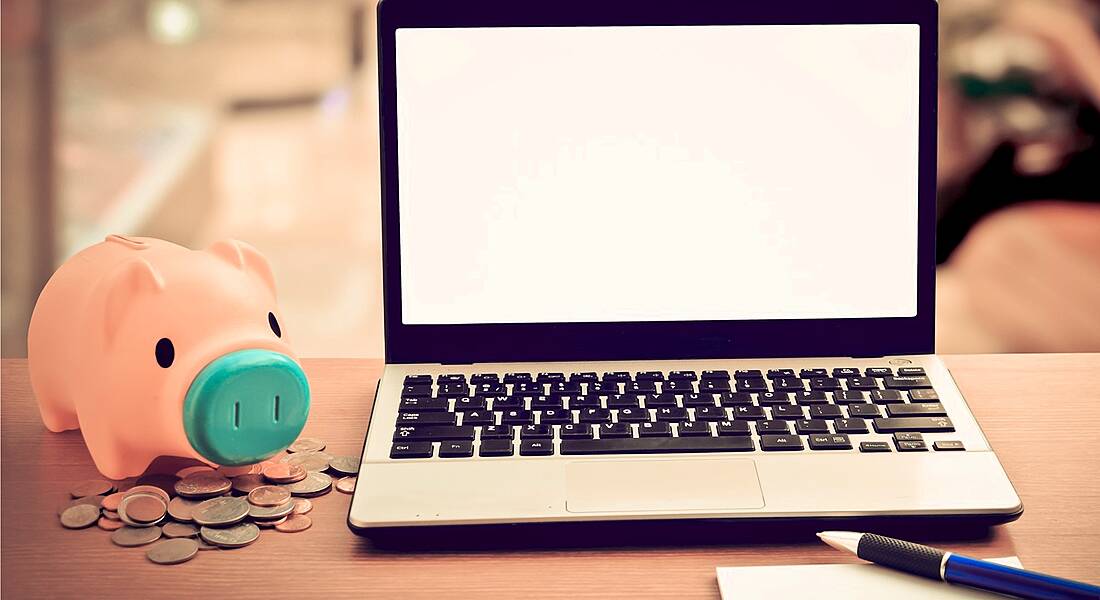 Piggy bank beside a laptop fintech twitter