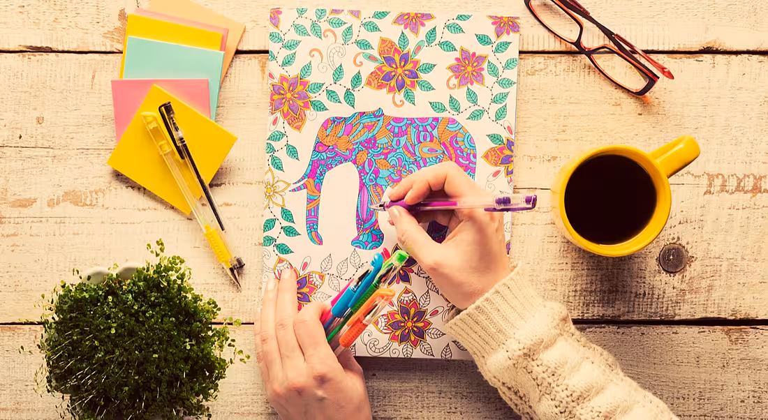 Stress busters: A woman calmly colouring on a desk