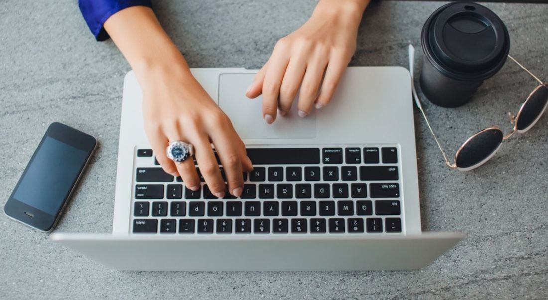 Aerial view of hands on a laptop to depict someone availing of free courses