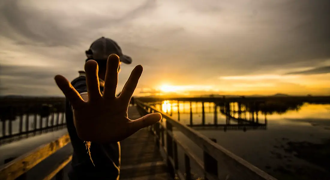 Man holding p 5 fingers at Sunset on pier. 5 ways inspirefest will inspire your career