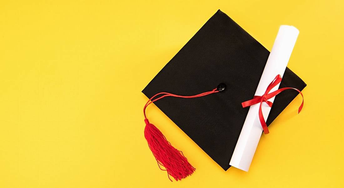 Graduation cap and scroll against yellow background. Results of Udemy survey into the most in-demand skills for 2018.