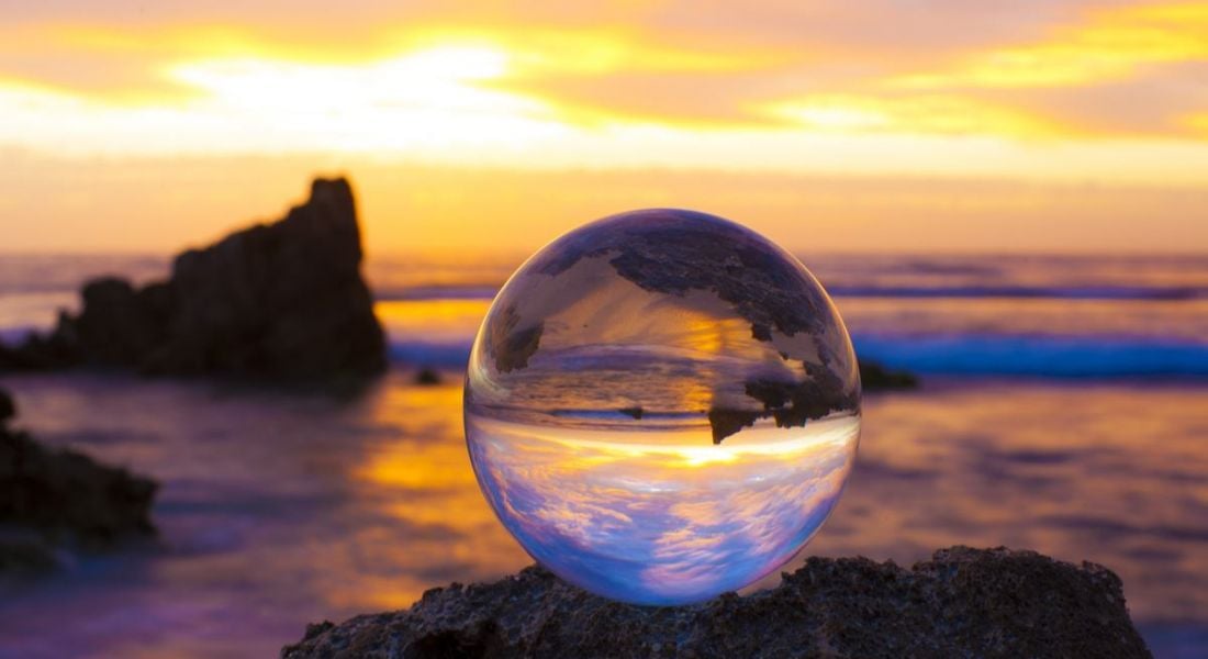 A crystal ball sitting on a beach up against the horizon. It will tell you what the future of work holds.