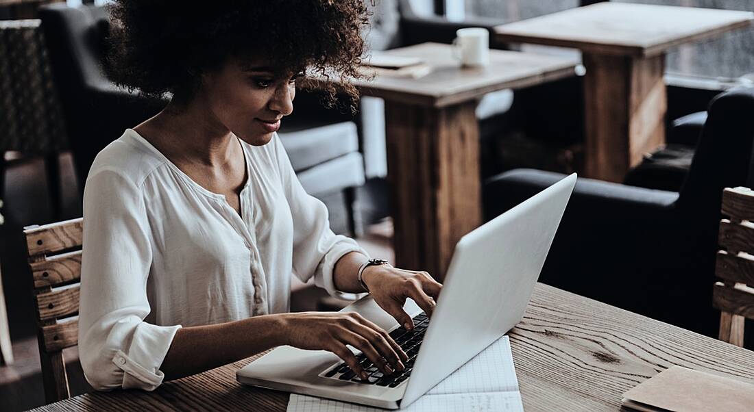 Woman using laptop at home to create her personal brand online