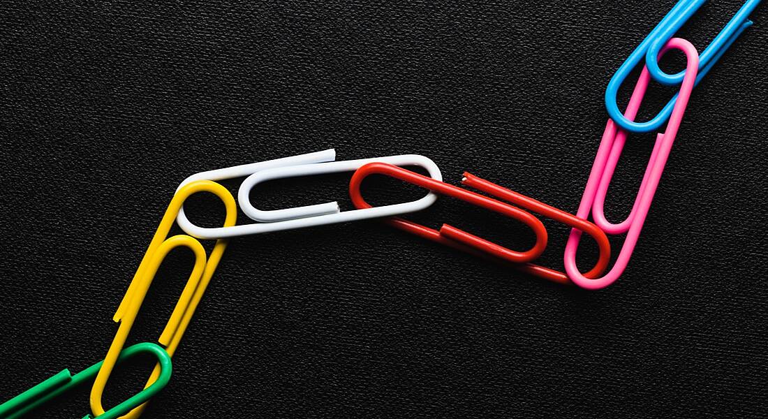 Colourful paperclips joined together to represent blockchain