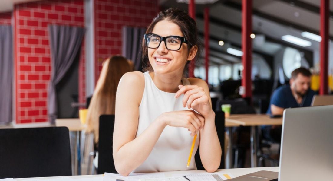 Young professional woman sitting at a desk in her new job and smiling