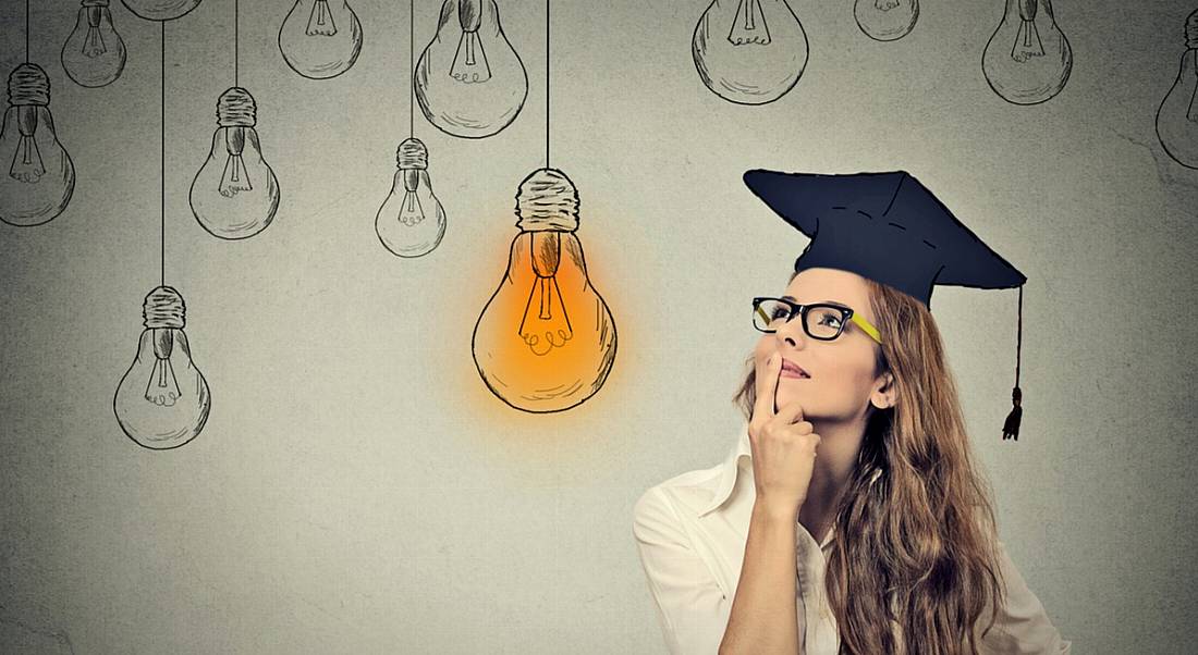 Young woman with graduate cap thinking about what she needs to know. There are sketched lightbulbs behind her and one is yellow to show its lit up.