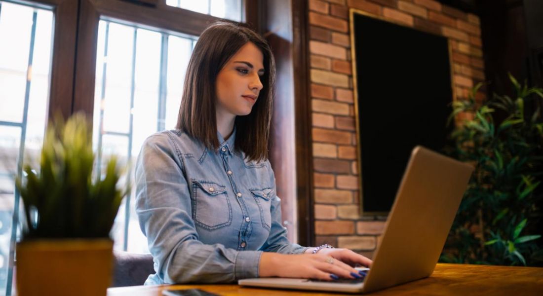 Young woman sitting at a laptop looking at graduate job applications