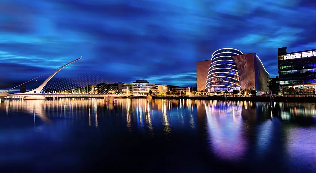 A view of the River Liffey with the white, arching Samuel Beckett Bridge and the cylindrical Convention Centre in Dublin.