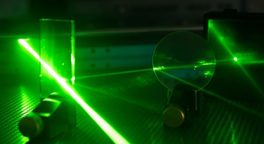 Green laser on optical table in a quantum optics laboratory showing a potential career in photonics.