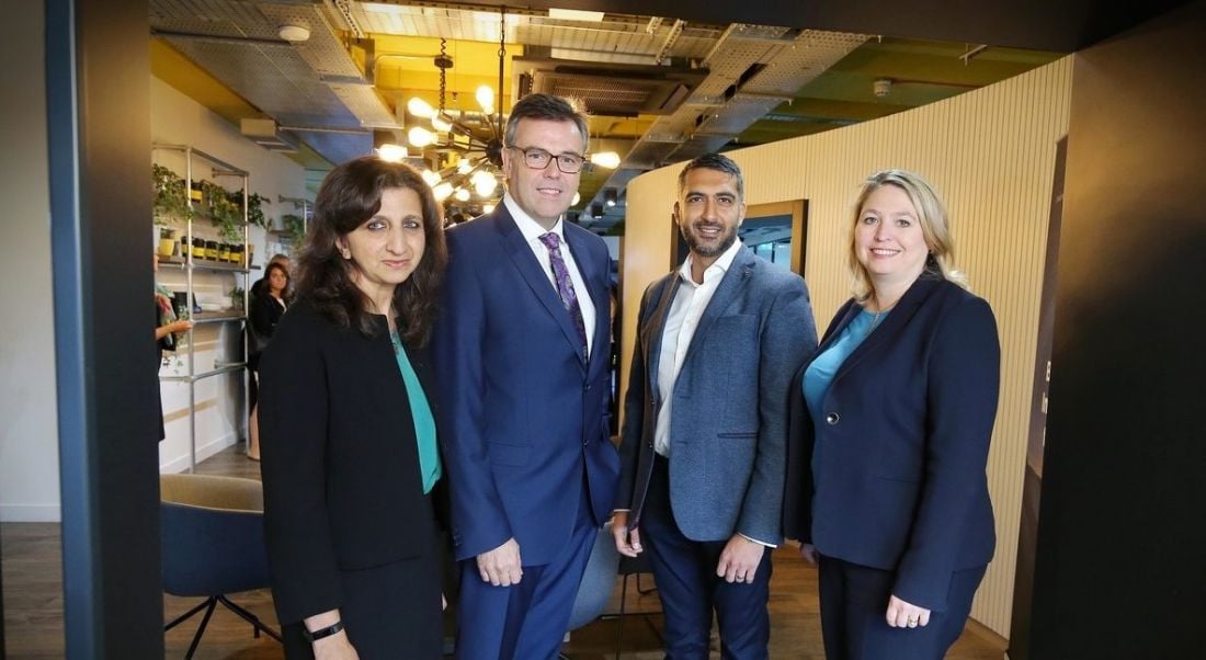 A group of professionals in formal business attire posing at the launch of the PA Consulting announcement.