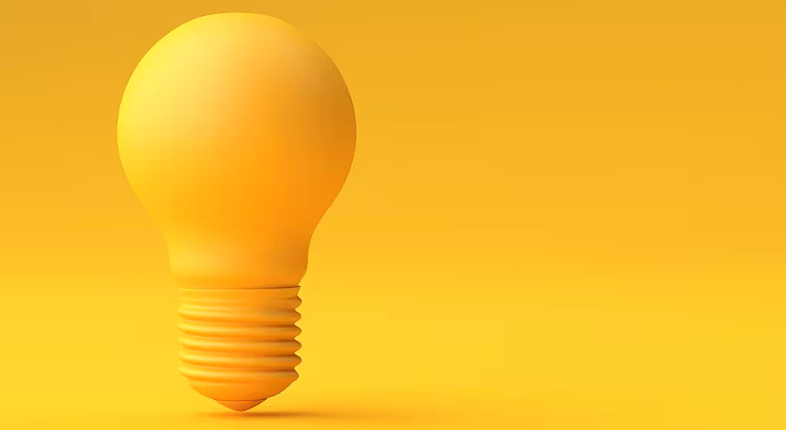 A yellow lightbulb standing alone against a yellow background, representing brainstorming as a concept.