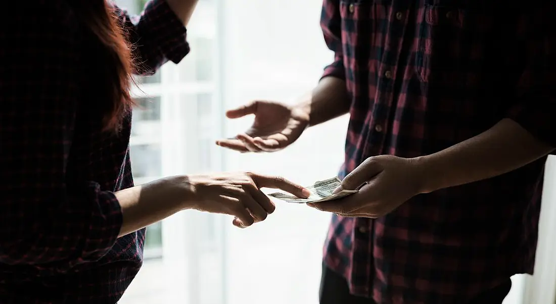 view of the torsos and hands of two employees sparring over workplace politics. They are both wearing checked shirts and both have their hands up in disagreement.