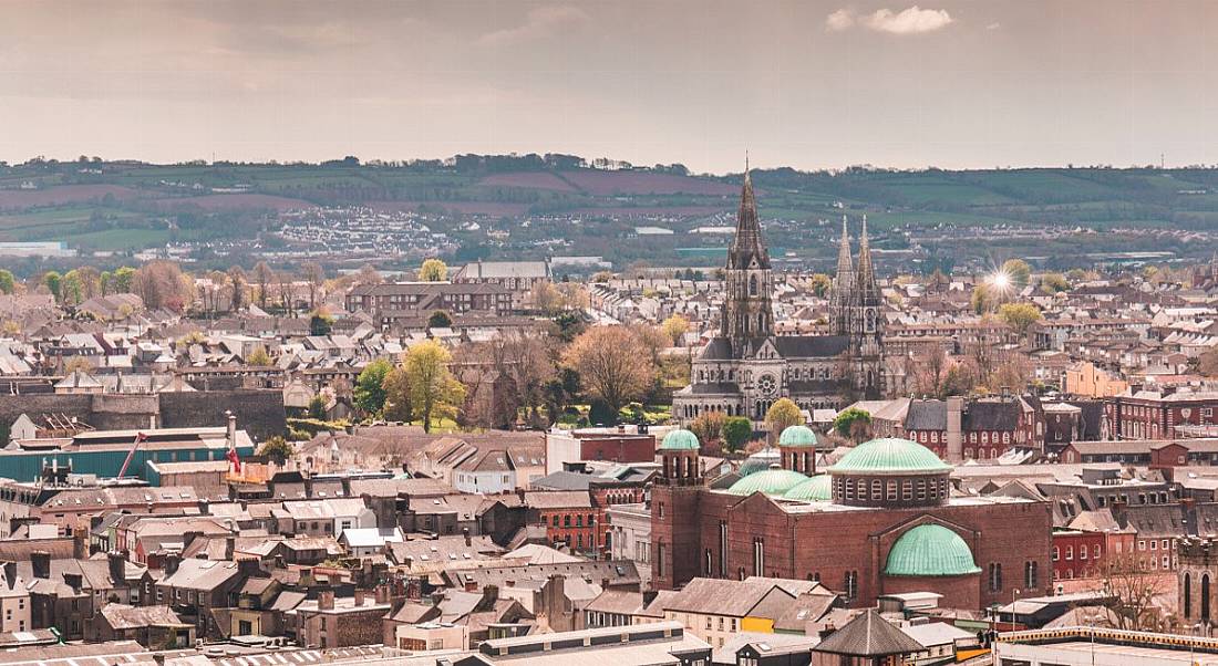 A panoramic view of Cork city with hills behind it.