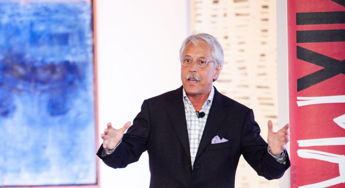Gary Hamel is a man with white hair and a moustache. He’s gesturing with his hands, speaking at a conference.