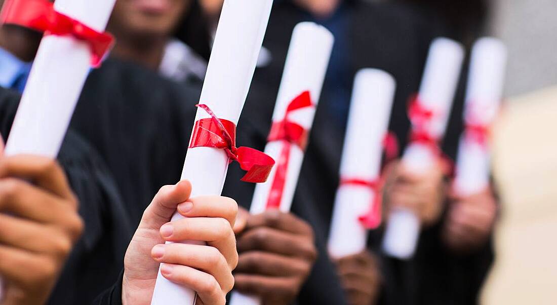 Representing advice for graduates is a close-up on a row of hands holding scrolls tied with red ribbon.