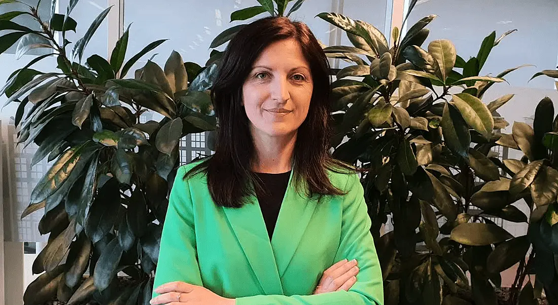 A headshot of a woman with dark hair wearing a bright green blazer. In this article, she talks about diversity.