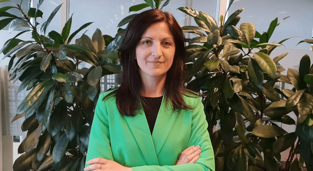 A headshot of a woman with dark hair wearing a bright green blazer. In this article, she talks about diversity.