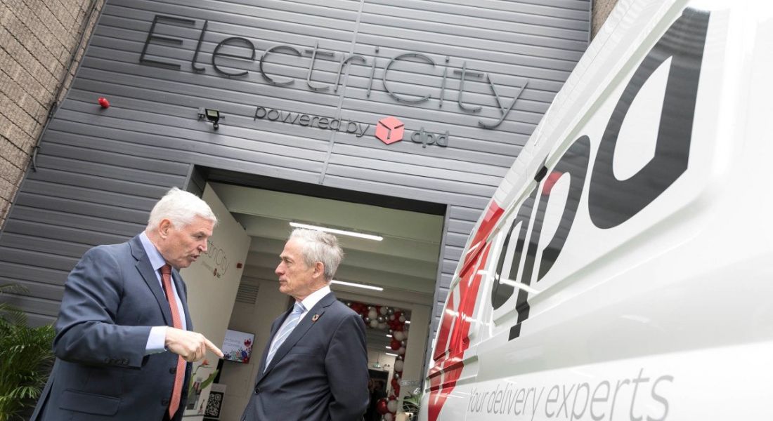 Two men in suits standing beside a DPD delivery van.