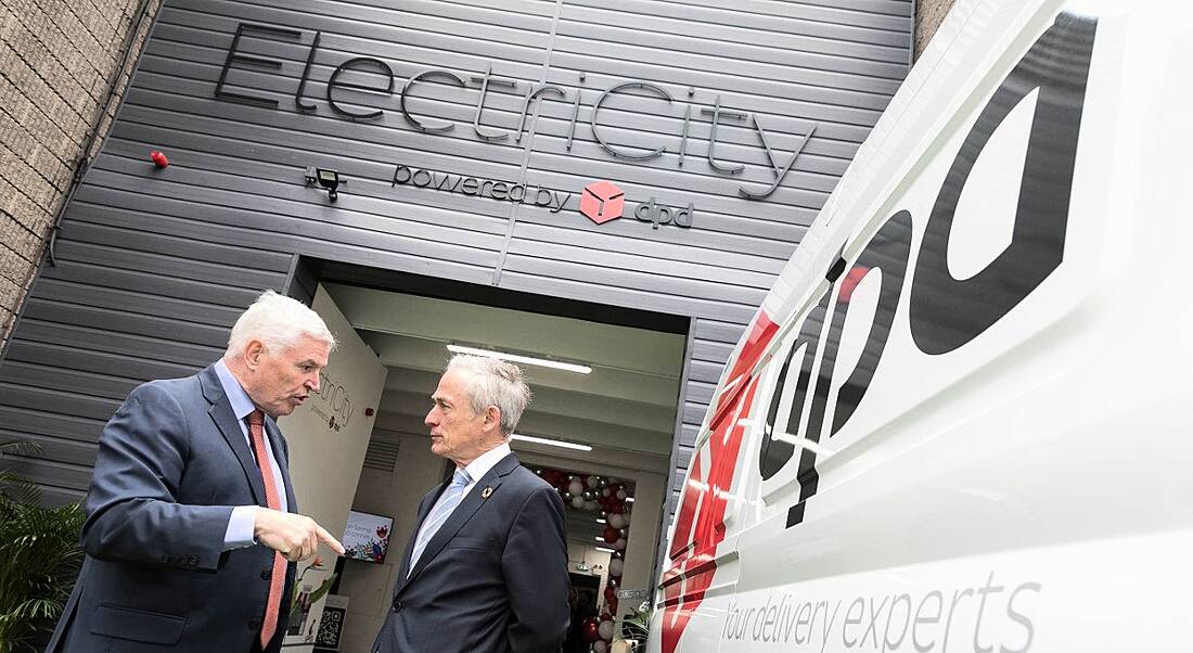 Two men in suits standing beside a DPD delivery van.