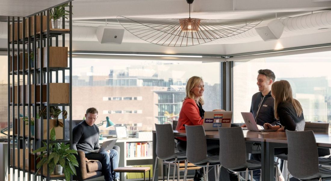 Workers sit around table and chairs at Stripe engineering offices in Dublin.