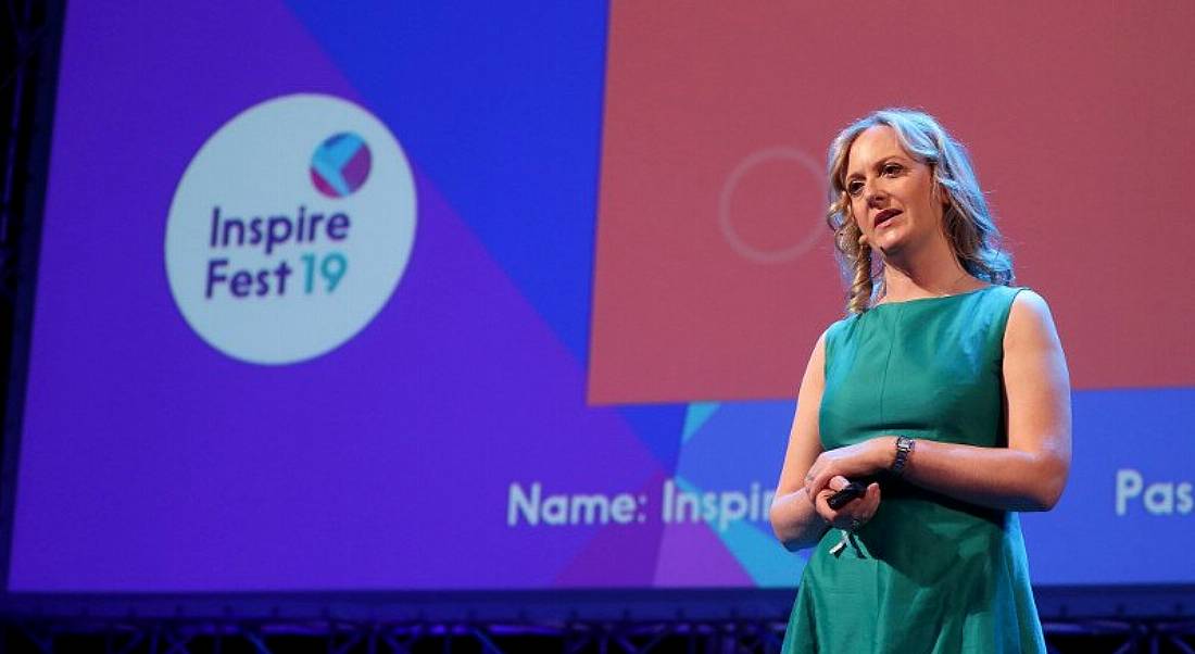 Woman in green dress with blonde hair standing on the Inspirefest 2019 stage.