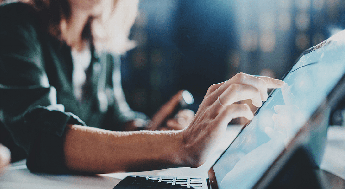 A man and woman working together on a computer screen.