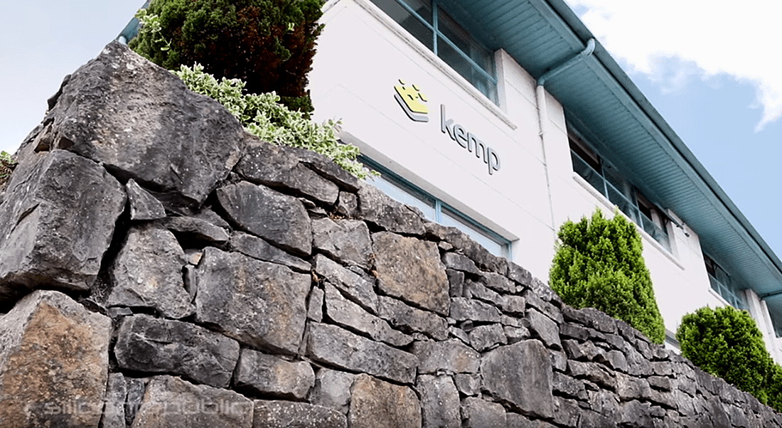 Shot looking up at Kemp offices in Limerick - a white stone building with plants around it.