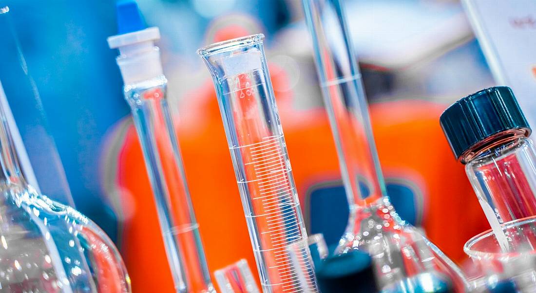 Close-up view of beakers crowded on a table in a life sciences lab.