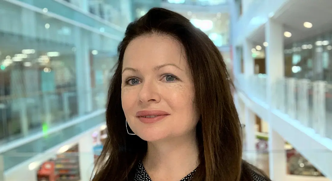 Headshot of a woman with brown hair in an office setting at Mastercard.