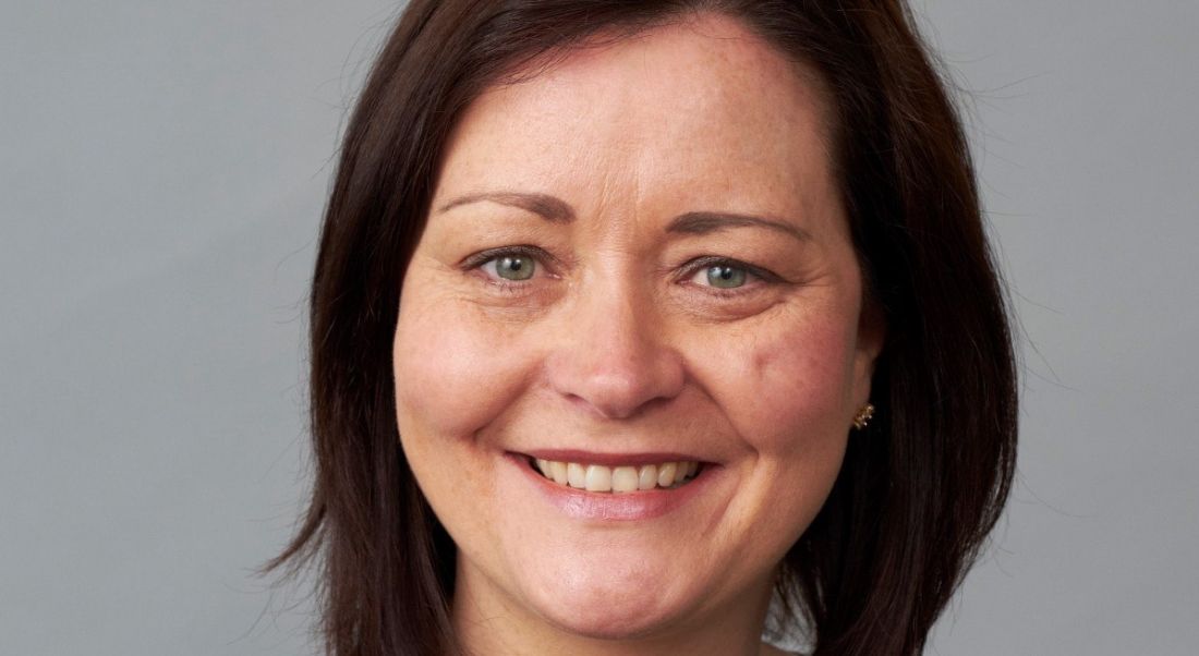 A headshot of a businesswoman with brown hair.