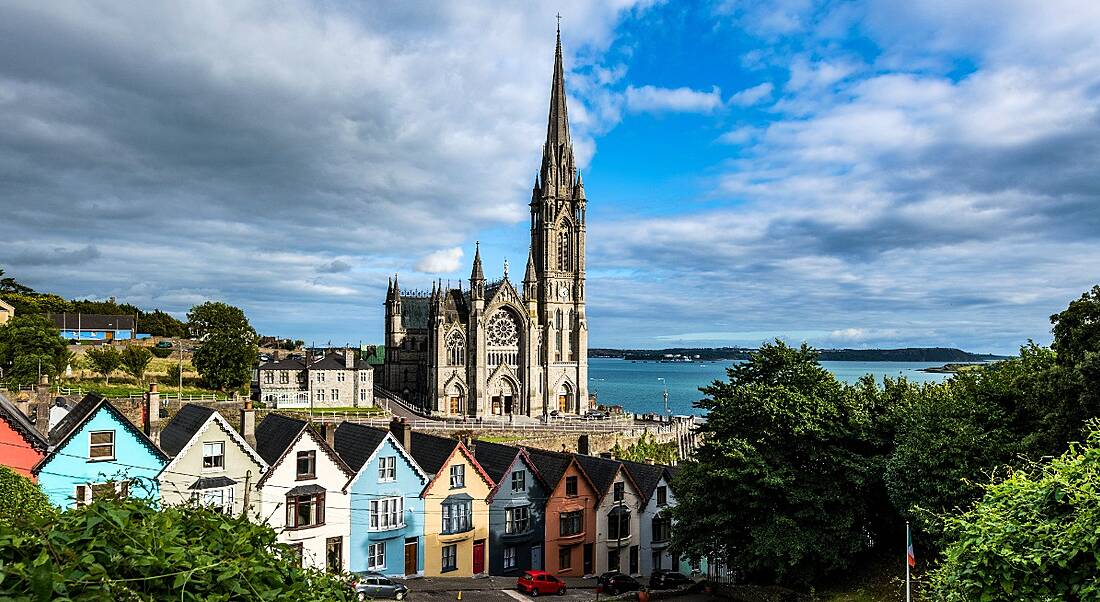 Photo of colourful houses in Cork, Ireland, with church spire in background.