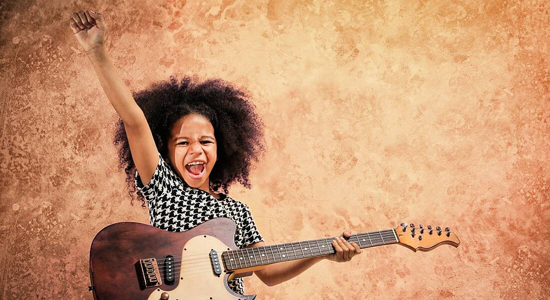 Young girl playing a guitar.